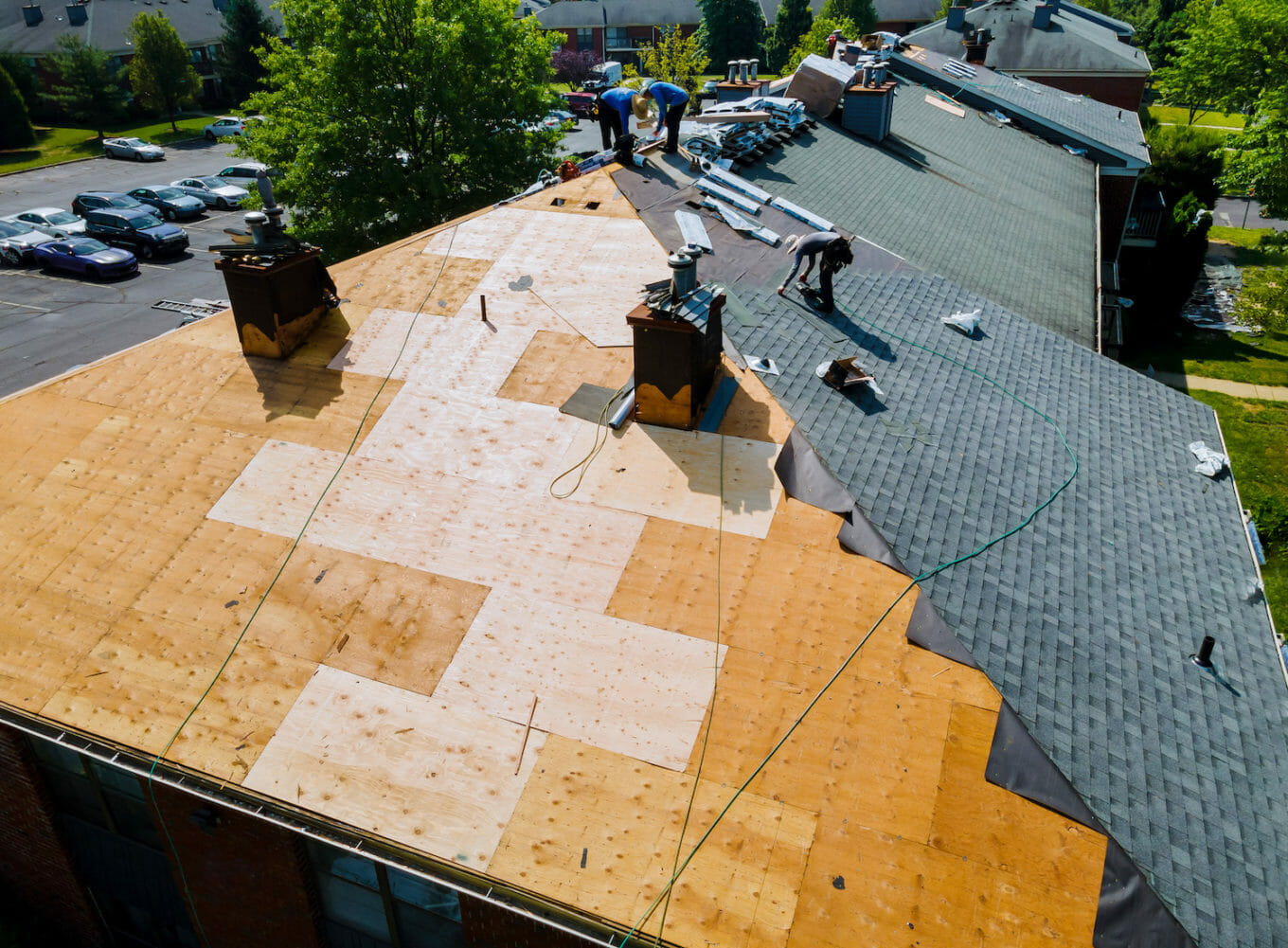 roof replacement cost and aerial view of a crew replacing a roof