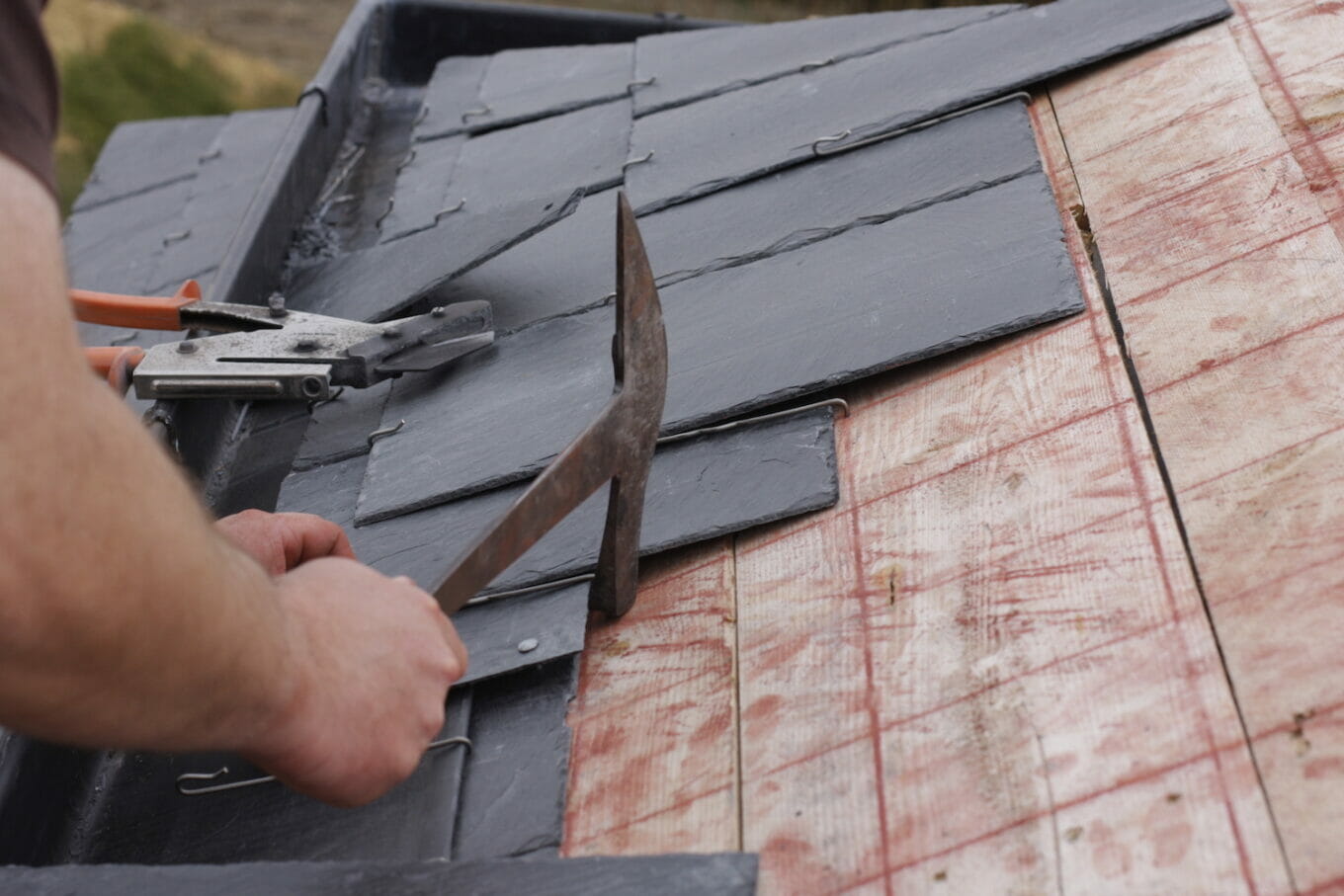 slate roof installation worker installing shingles